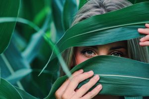 woman-covering-her-face-with-corn-leaves-906024